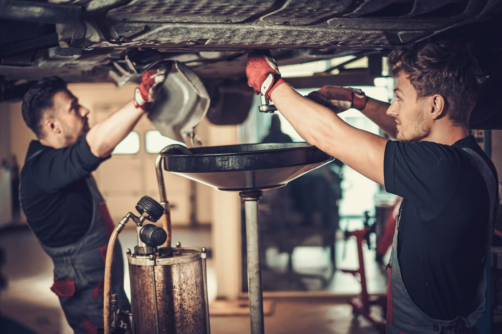Two Ford Technicians Changing Car Oil